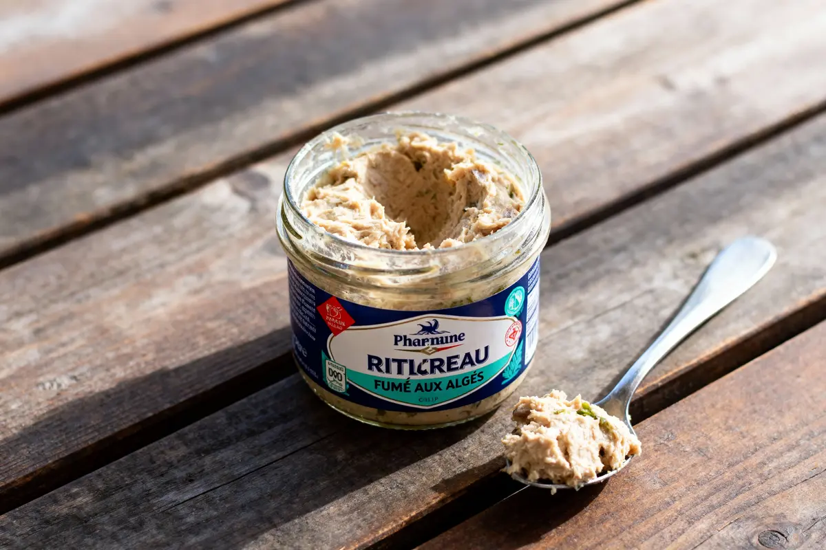 Pot de rillettes de la mer sur table en bois, avec cuillère contenant préparation fumée aux algues.
