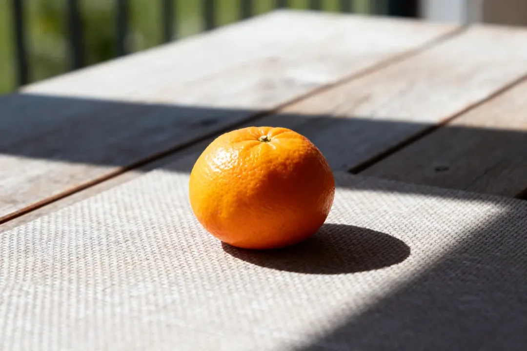 Clémentine posée sur une table en bois éclairée par le soleil calories d'une clémentine