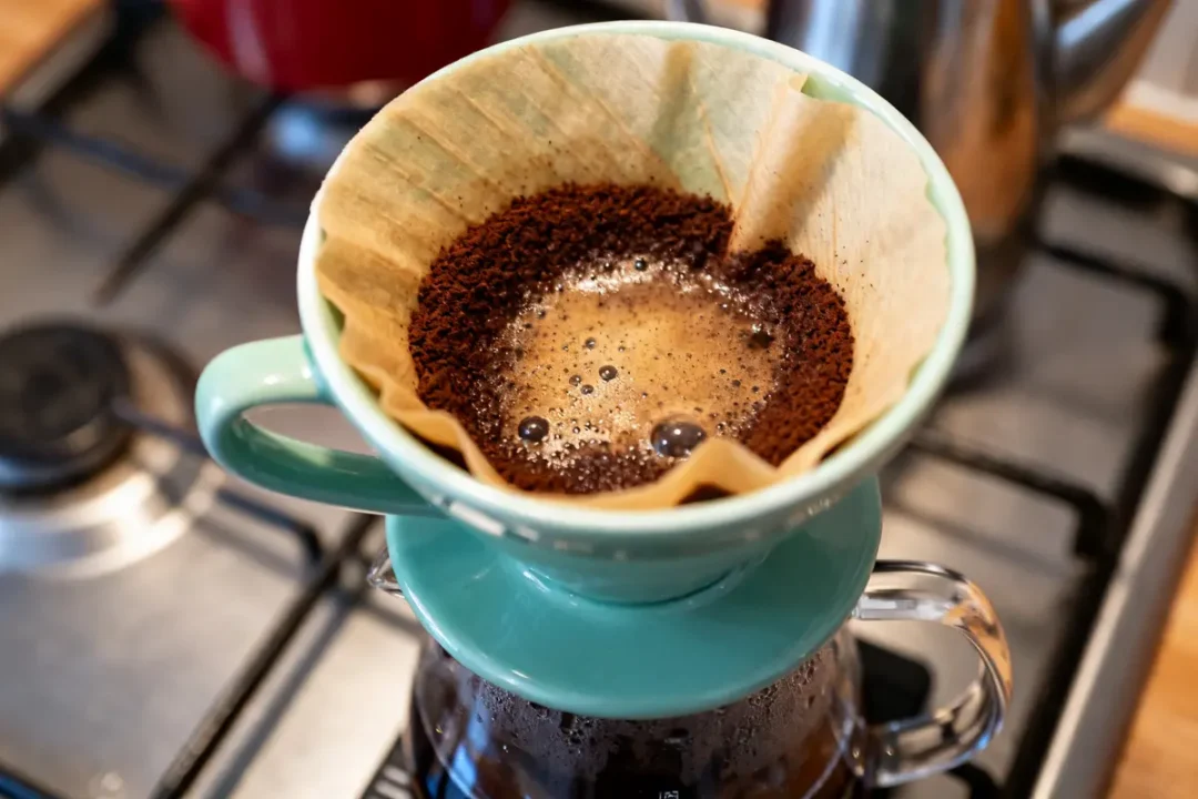 Préparation café filtre au dosage café filtre 10 tasses sur cafetière verte en cuisine
