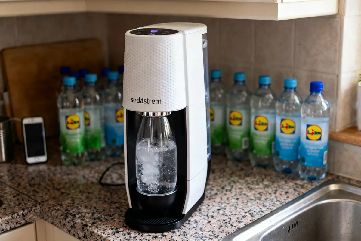 Machine Sodastream Lidl sur comptoir avec bouteilles d'eau Lidl en arrière-plan