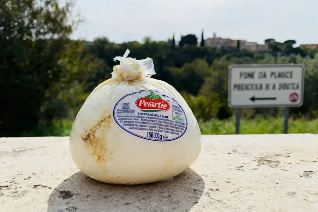 Paquet de mozzarella périmée posé sur un muret en extérieur près d'un panneau routier
