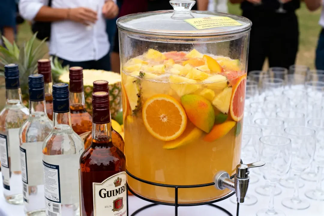 Grande jarre de punch tropical avec bouteilles pour recette de punch pour 50 personnes